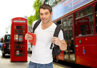 Image showing happy young man with backpack and book travelling