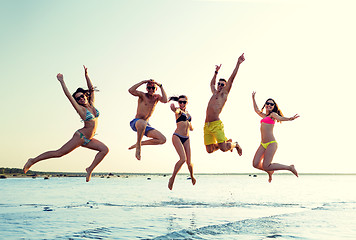 Image showing smiling friends in sunglasses on summer beach