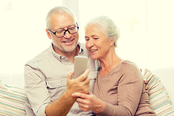 Image showing happy senior couple with smartphone at home