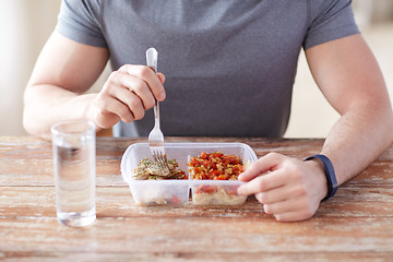 Image showing close up of man with fork and water eating food