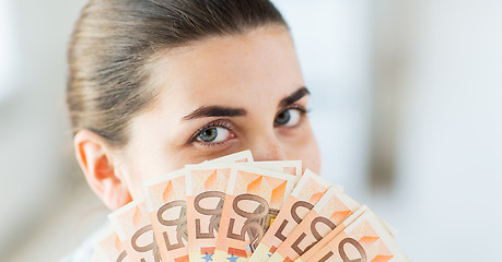 Image showing woman hiding her face behind euro money fan