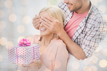 Image showing happy man giving woman gift box at home