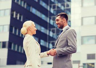 Image showing smiling businessmen standing over office building