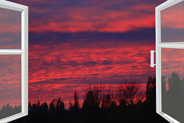 Image showing window opened to the dark scarlet sunset