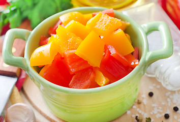 Image showing red and yellow peppers on wooden background