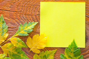 Image showing note and leaves on wooden background