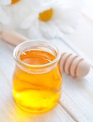 Image showing fresh honey in the glass bank and camomiles