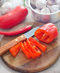 Image showing Raw red peppers on the wooden board