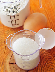 Image showing Sugar, flour and raw eggs on the wooden board