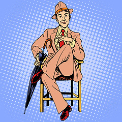 Image showing Elegant man with an umbrella sitting on the stool