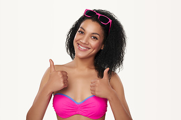 Image showing Smiling woman in swimsuit gesturing thumb up