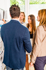 Image showing Businesspeople looking at bulletin board in office