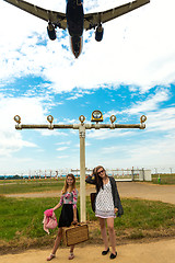 Image showing Two girls hitchhiking a plane