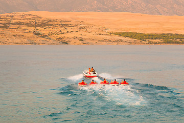 Image showing Kids tube riding tawed by speedboat.