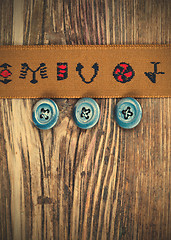 Image showing vintage tape with embroidered ornaments and old buttons