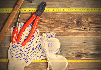 Image showing vintage hammer, pliers, screwdriver, tape measure, gloves and sa