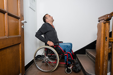 Image showing man in wheelchair facing a barrier of stairs