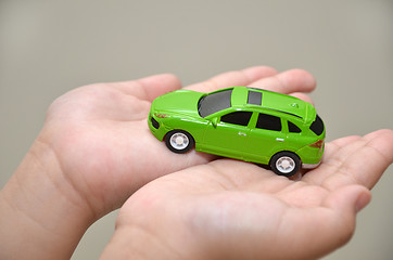 Image showing Green toy car on hand 