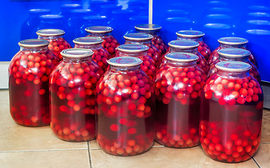 Image showing Home canning: large glass cylinders with cherry compote.