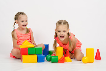 Image showing Two girls laughing uncontrollably playing dice