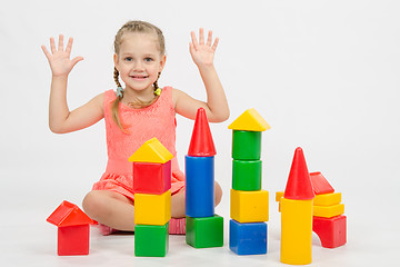 Image showing Girl happily raised his hands, playing with blocks