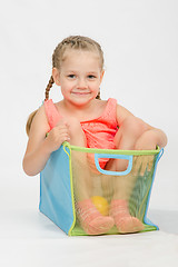 Image showing Cheerful girl in a box for toys