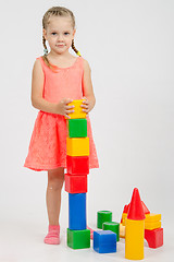 Image showing Four-year girl builds a pyramid of cubes