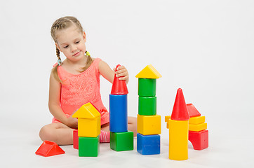 Image showing The girl puts on a tower house from cubes