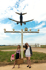 Image showing Two girls hitchhiking a plane