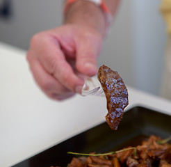 Image showing dish of pork with sauce on black plate