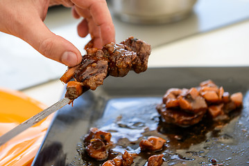 Image showing dish of pork with sauce on black plate