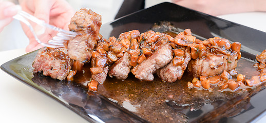 Image showing dish of pork with sauce on black plate