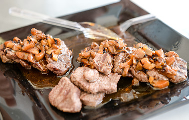 Image showing dish of pork with sauce on black plate