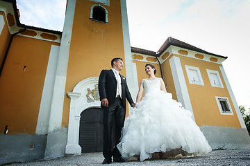 Image showing Newlyweds posing in front of castle