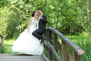 Image showing Bride and groom on wooden bridge in nature