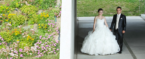 Image showing Bride and groom posing under the overpass