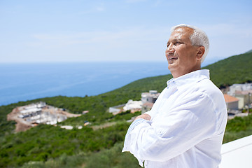 Image showing senior man in front of modern home