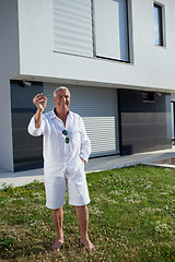 Image showing senior man in front of modern home