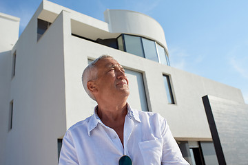 Image showing senior man in front of modern home