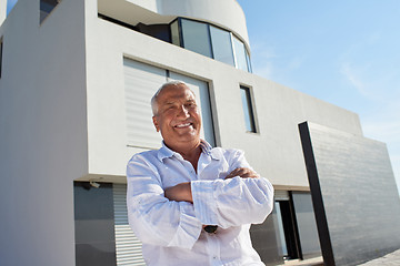 Image showing senior man in front of modern home