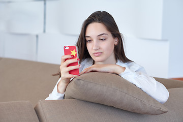 Image showing young woman using cellphone at home