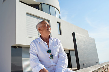 Image showing senior man in front of modern home