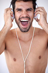 Image showing handsome young man listening music on headphones