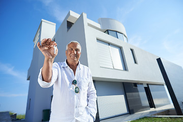 Image showing senior man in front of modern home