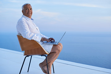 Image showing senior man working on laptop computer