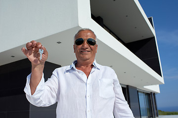 Image showing senior man in front of modern home