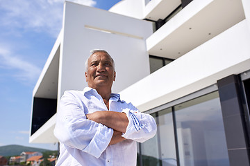 Image showing senior man in front of modern home