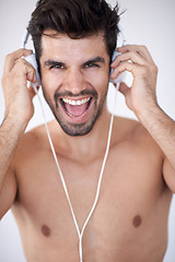 Image showing handsome young man listening music on headphones