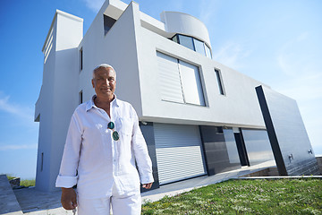 Image showing senior man in front of modern home