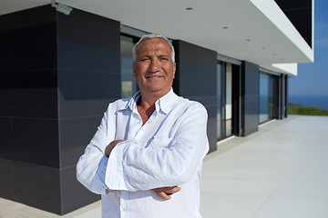 Image showing senior man in front of modern home